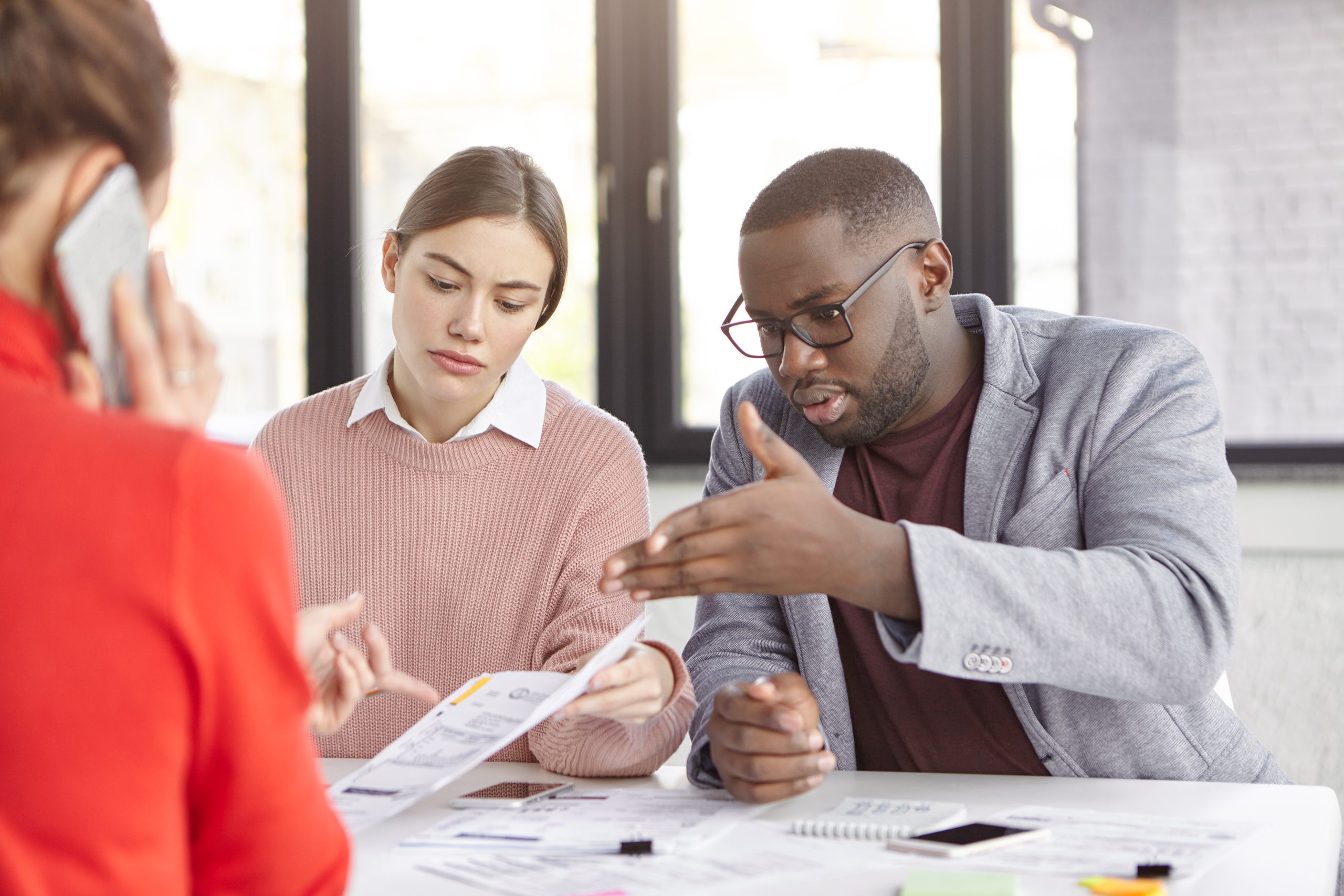 Experienced coach of working team checks projects, meets with female colleagues, discuss opinions and ideas as look into documents, solve problen during informal meeting at office. Cooperation concept